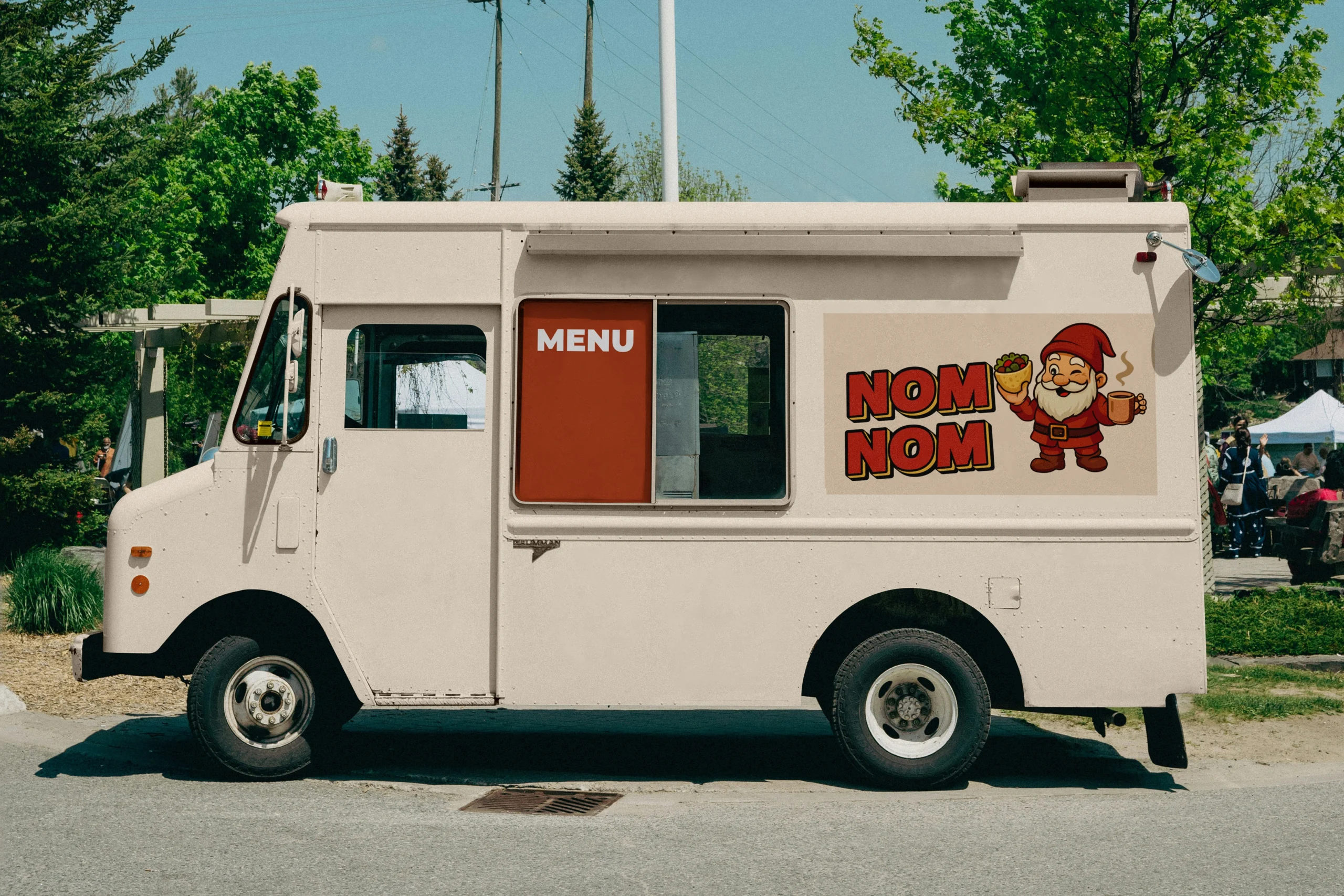 Weißer NOM NOM Foodtruck mit Logo und Gnom-Maskottchen als Fahrzeugbeschriftung – Signage Branding